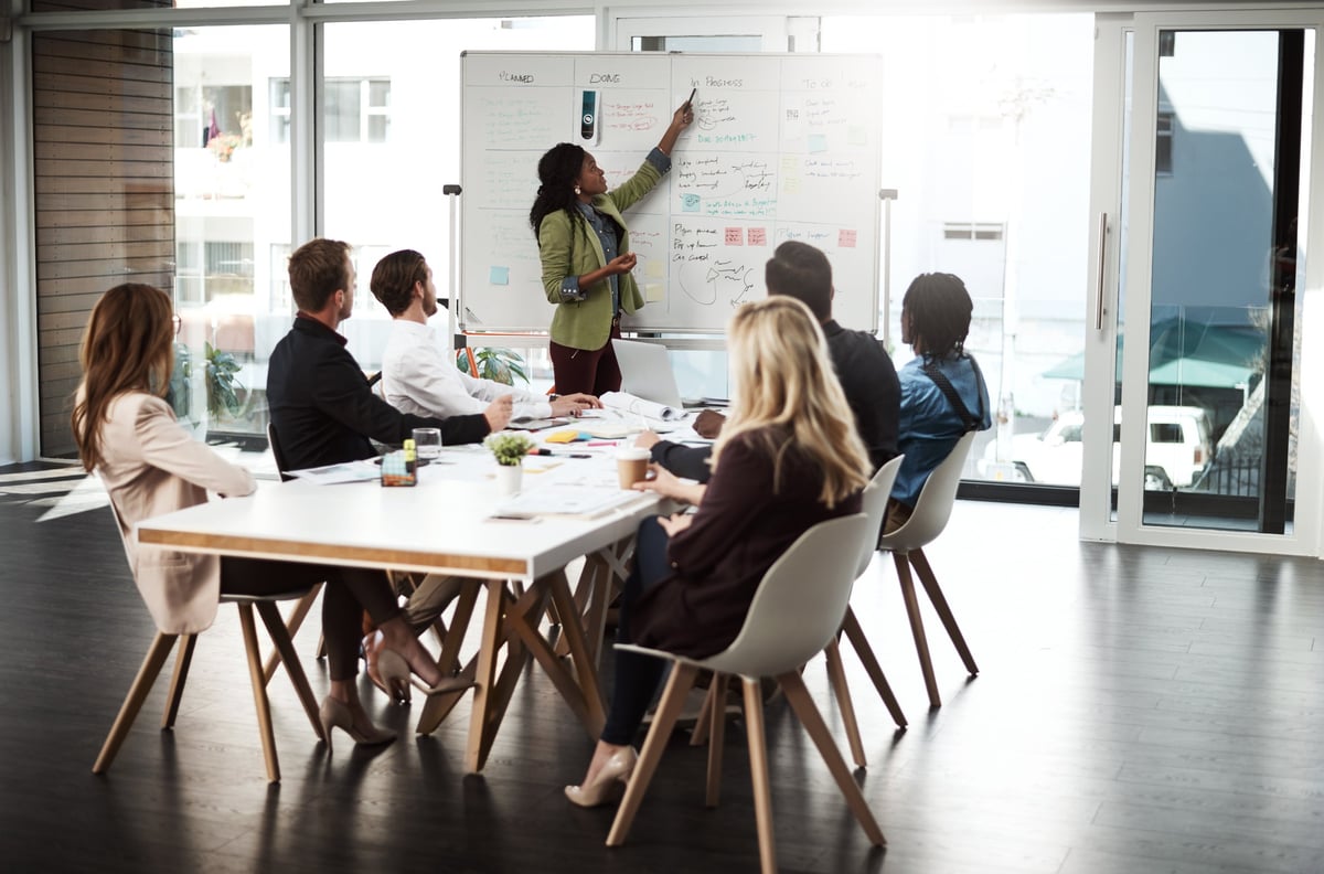 Shot of a businesswoman giving a presentation to her colleagues on a whiteboard in a boardroom