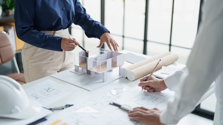 Commercial lease solicitors for architects reviewing lease documents with architecture firm partners in a design studio