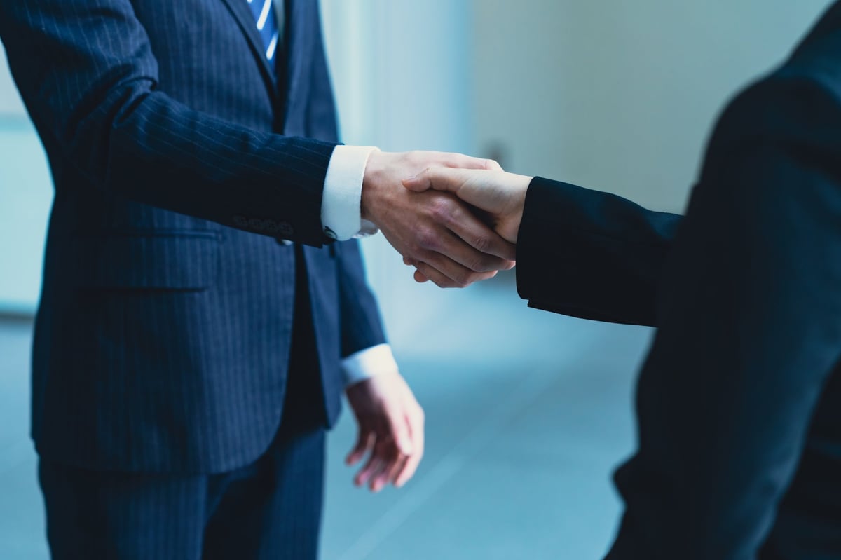 Business professionals shaking hands during commercial lease negotiation meeting