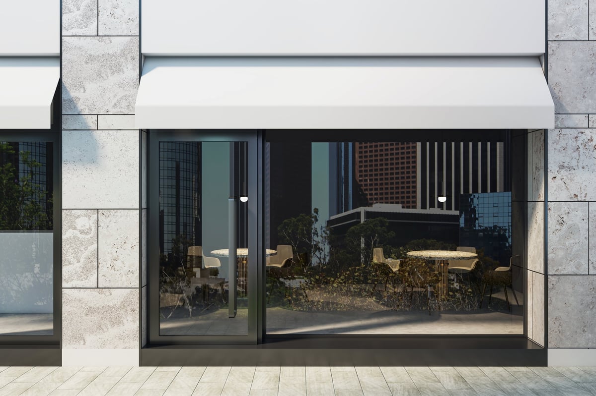 Empty modern shop exterior with large glass windows and stone facade on a city street