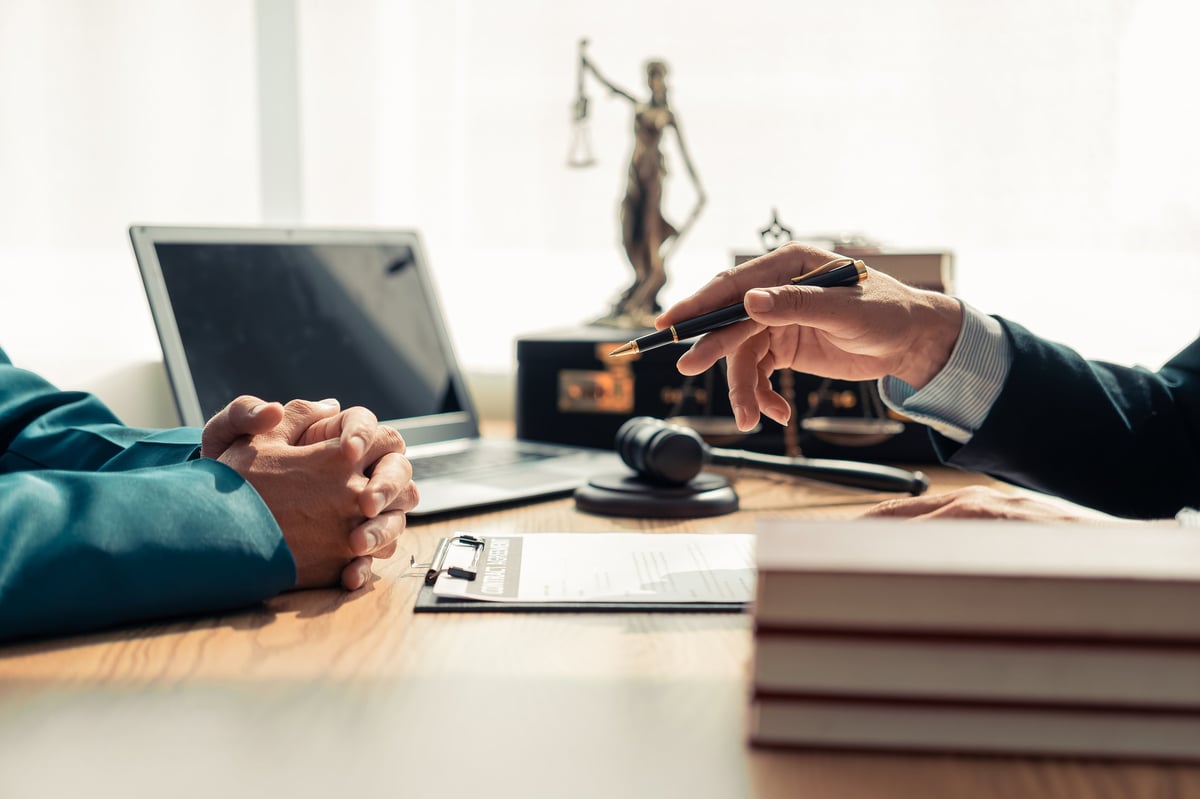 Professional lawyer advising client on commercial contract in law office. Concept of judicial process, law, lawyer and judge in court with gavel banging on table.