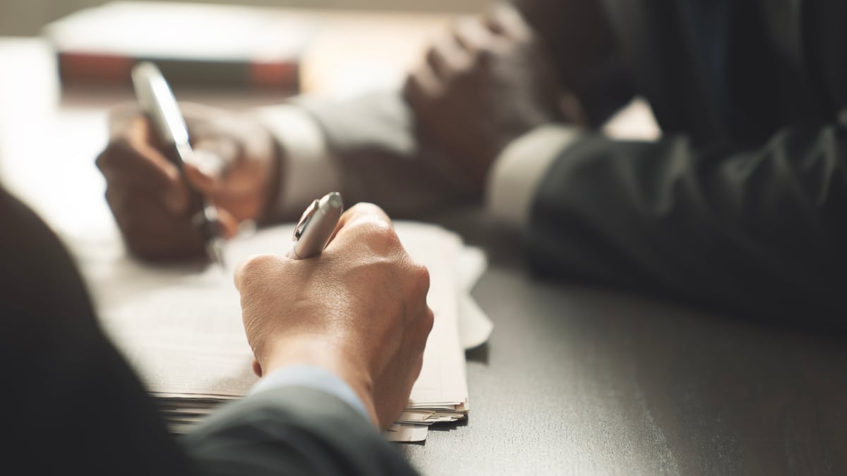 Businessperson signing a lease agreement on a desk, illustrating break clause notice requirements in commercial leases