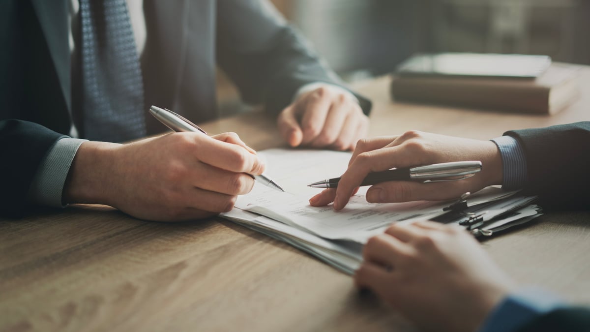 Business tenant reviewing a commercial lease document with legal advisor in modern office