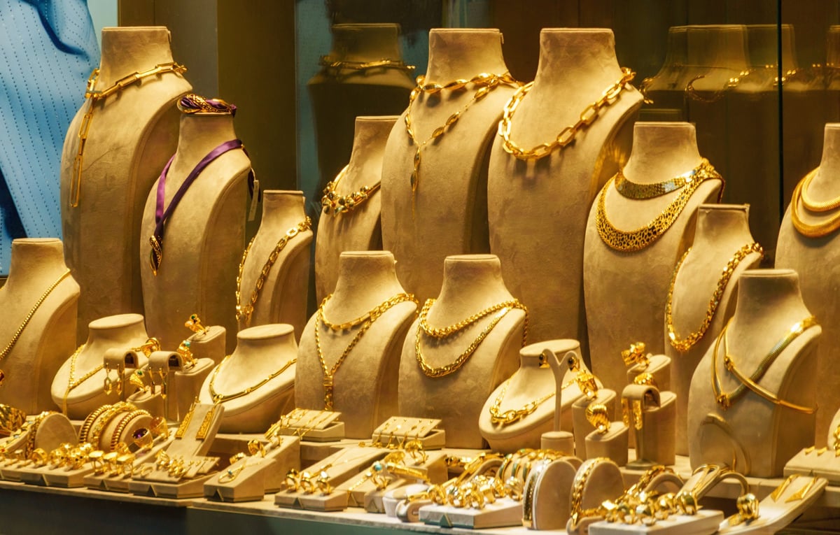 Elegant display of luxury gold necklaces and jewelry on velvet busts in a boutique shop window