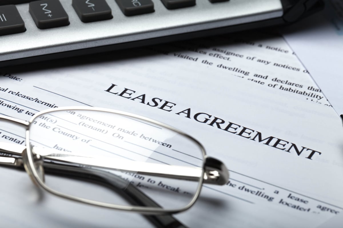 Business tenancy and commercial lease documents with glasses, pen and calculator in England and Wales